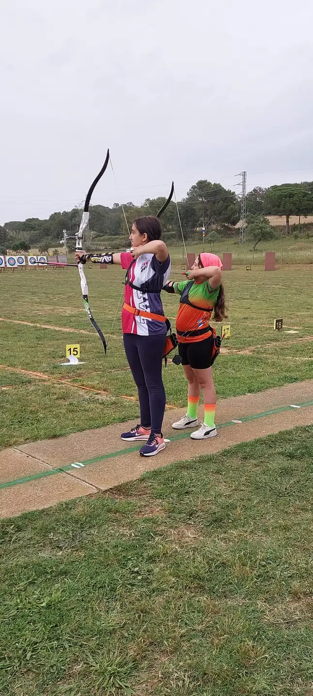 dos arqueras jovenes tirando con arco desnudo