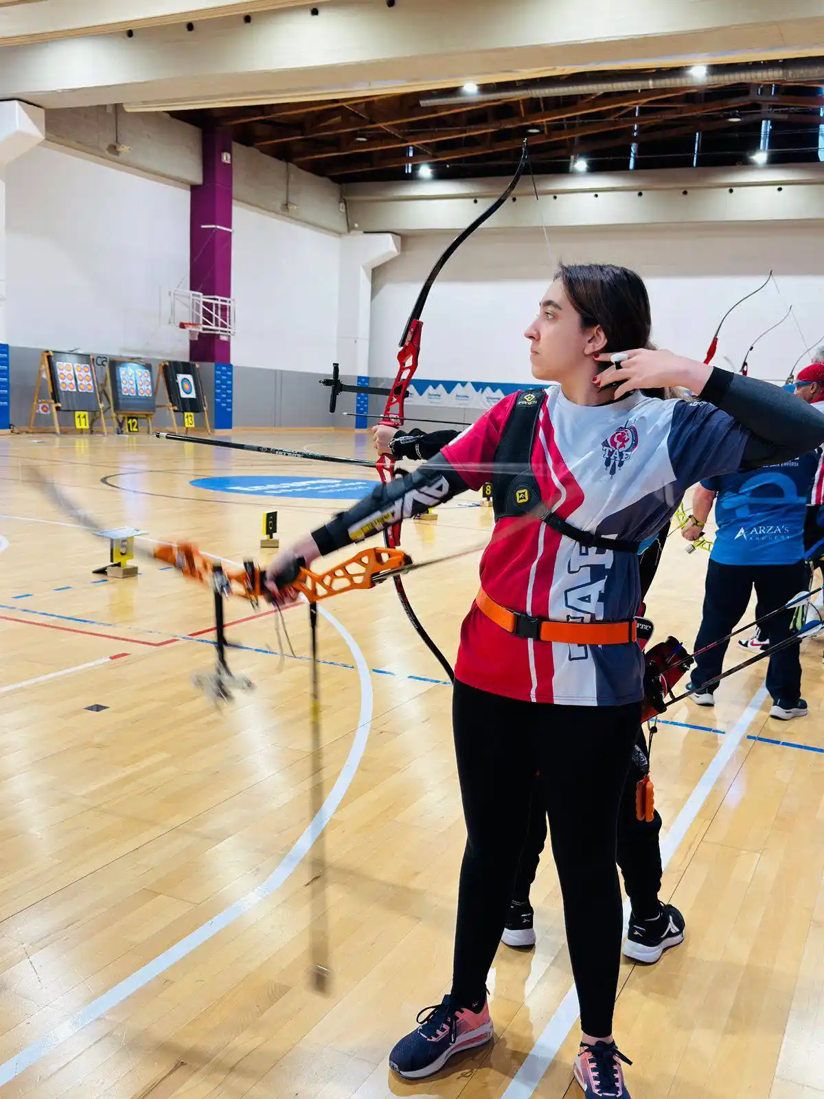 arquera joven de arco recurvo tirando